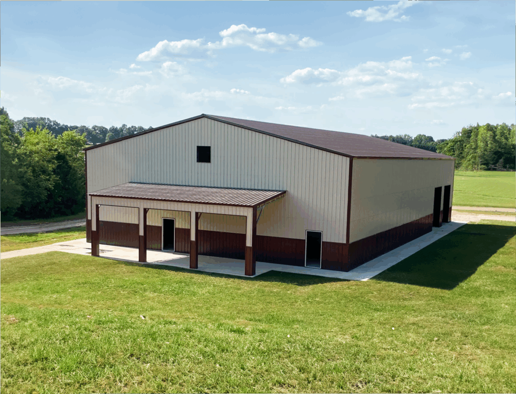 Modern commercial metal building with beige and brown vertical siding, gable roof, and multiple access doors, set on a concrete foundation in a spacious grassy field—ideal for storage, agricultural, or industrial use.